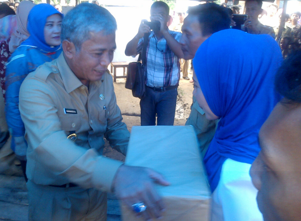 Bupati OKI H Iskandar SE didampingi Ketua TP PKK OKI Hj Lindasari Iskandar menyerahkan bantuan kepada bidan Desa Parit Raya Kecamatan Cengal pada kunjungan tandang desa tertinggal.